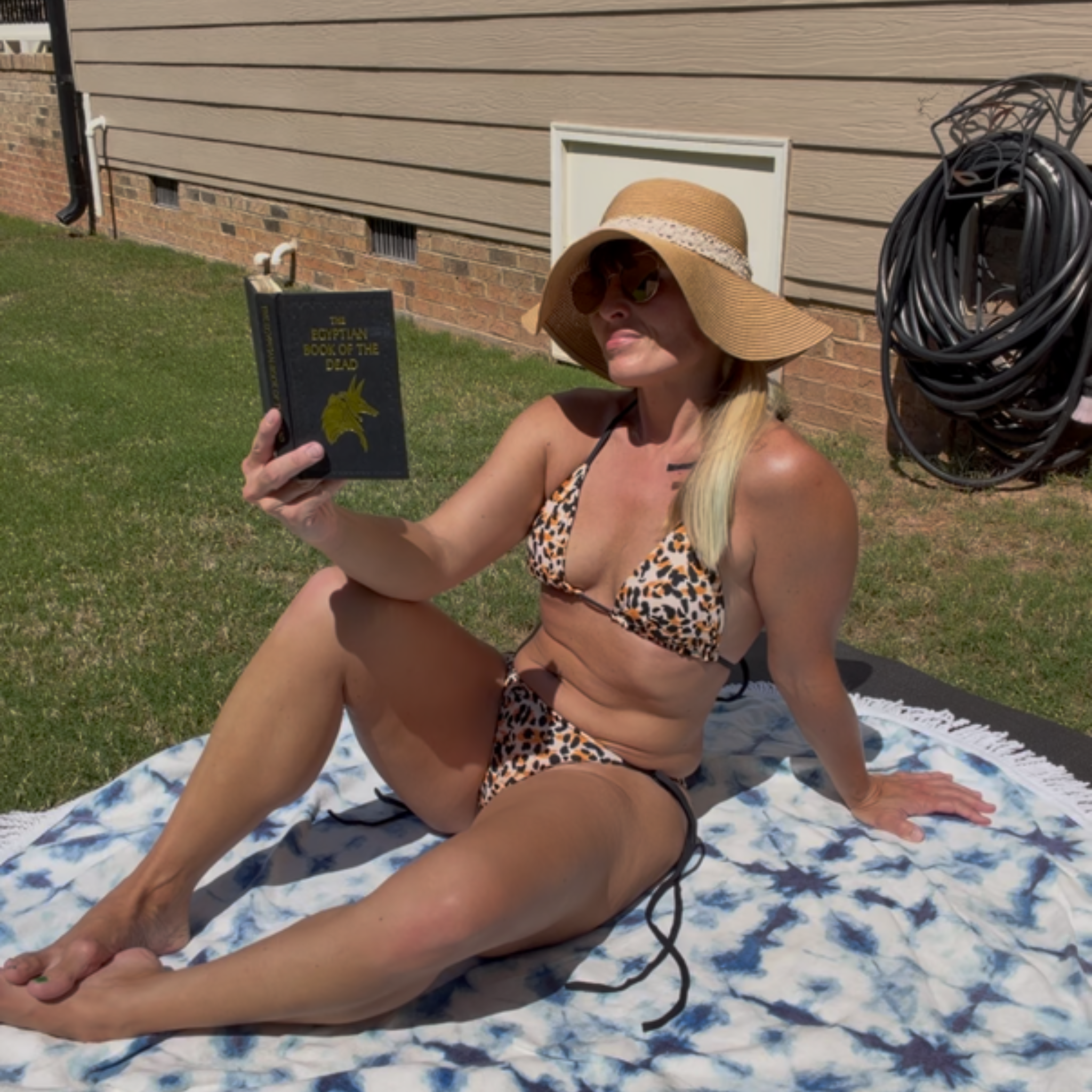 woman laying on a blanket and reading a book  wearing Savage cheetah string bikini by My Velveteen Habit